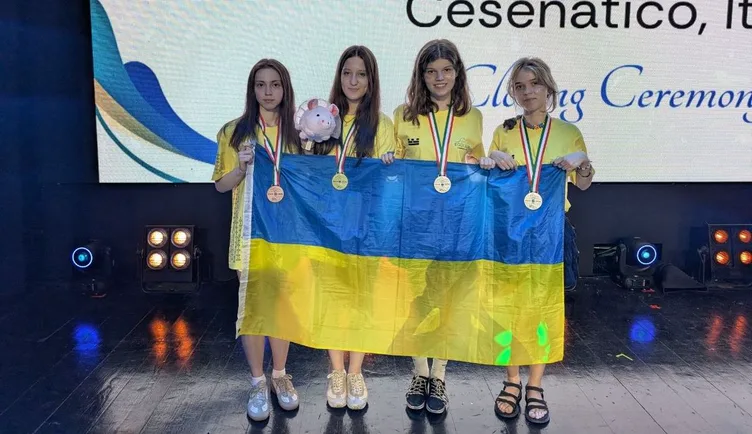 Четверо учасниць збірної України з прапором на сцені закриття EGOI 2026